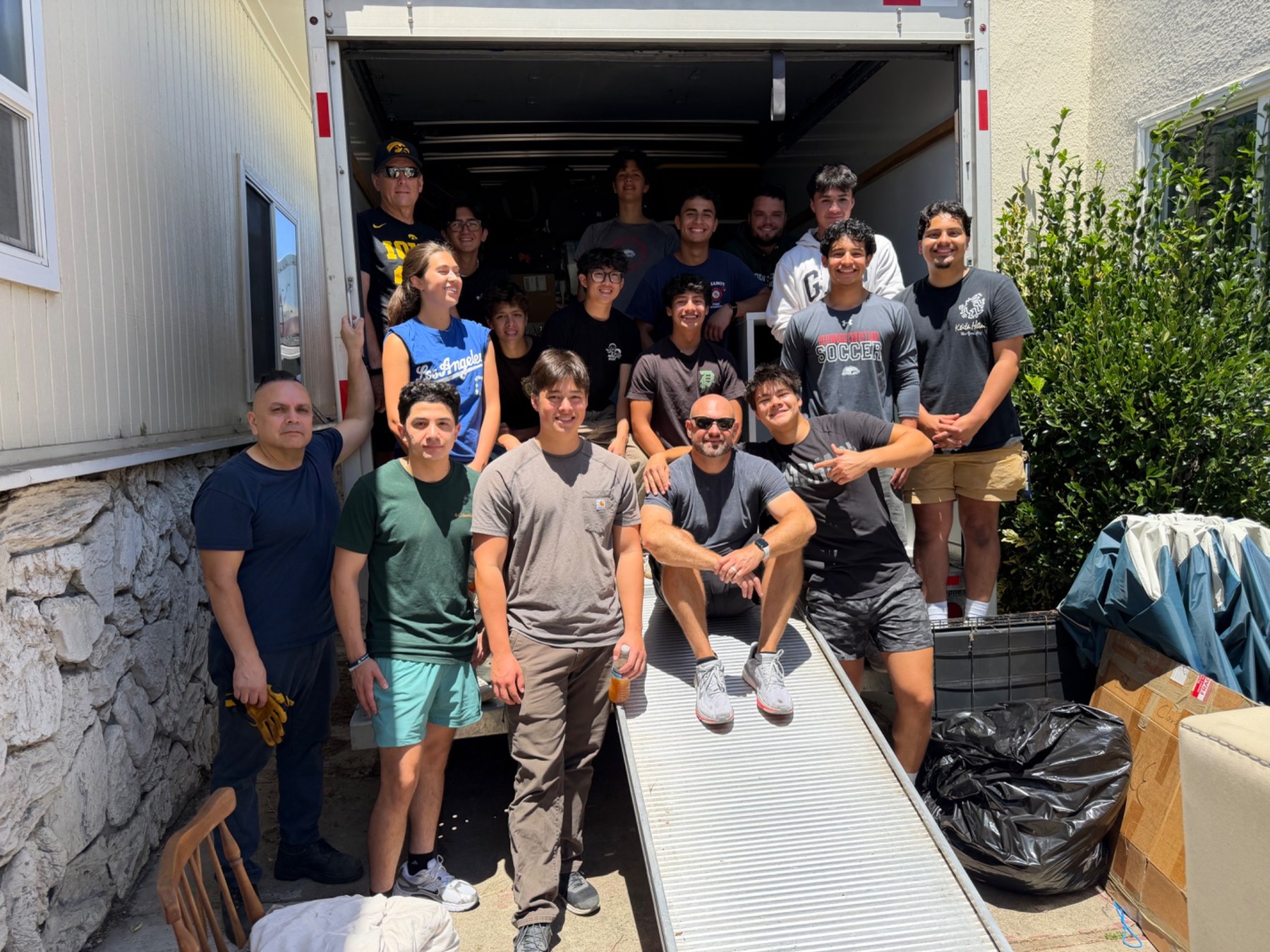 Former players, students, coaches, and friends helping the Hinton family load their moving truck